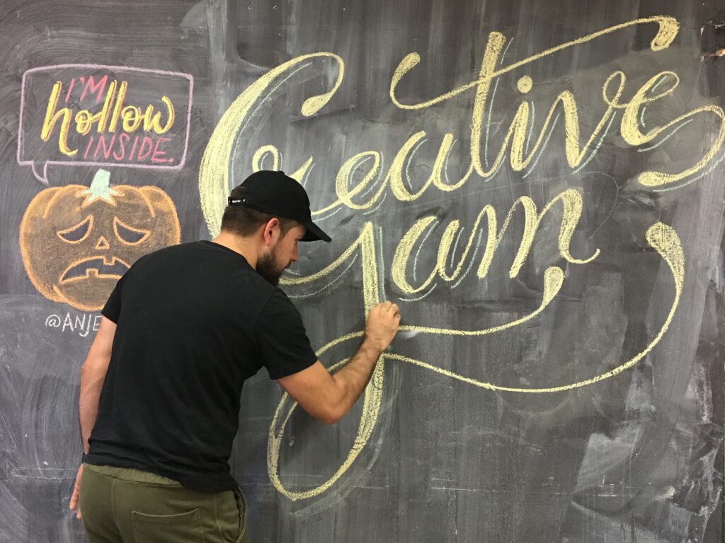 student writing creative jam on chalkboard