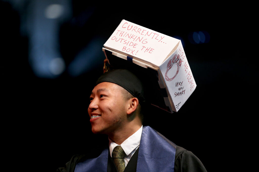 Fresno State student in graduation regalia with a decorated cap