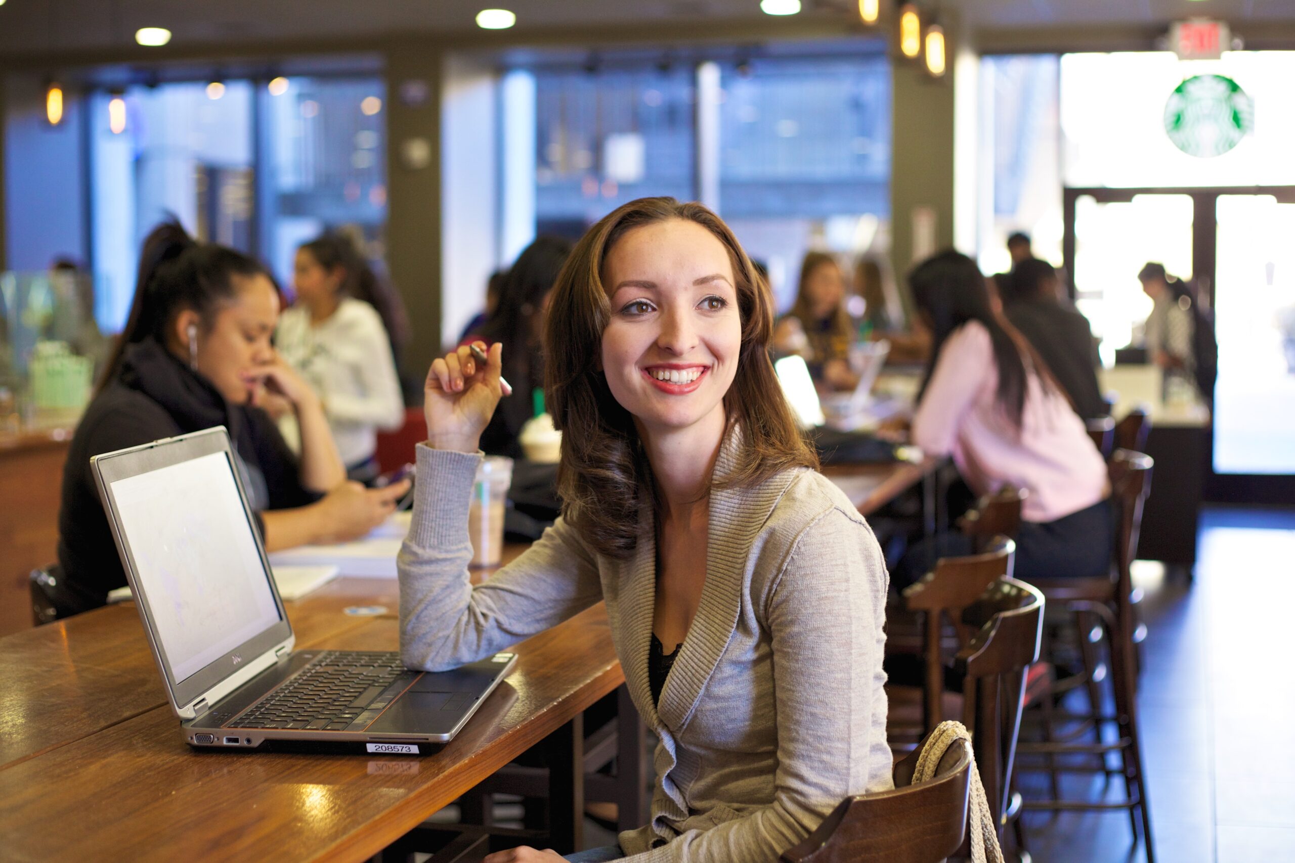 Woman sitting at a communal desk with a laptop